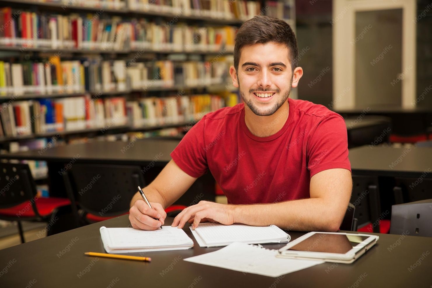 University student smiling in library while studying